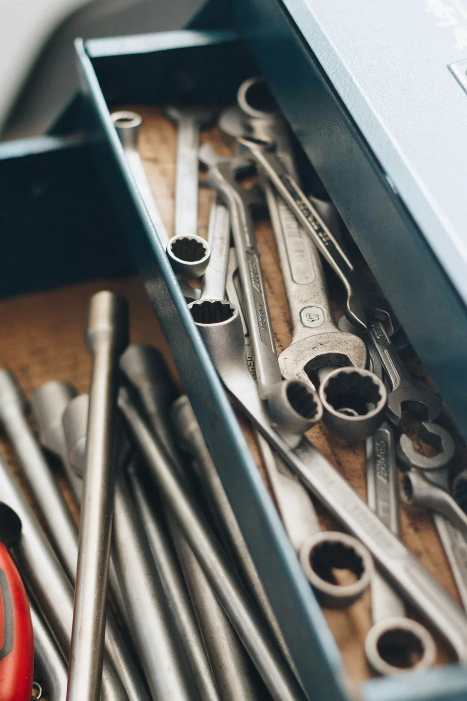 A steel toolbox drawer full of wrenches and sockets